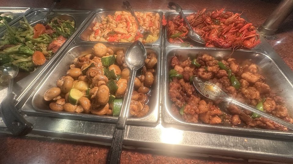 Printed menu beside buffet-style dishes.