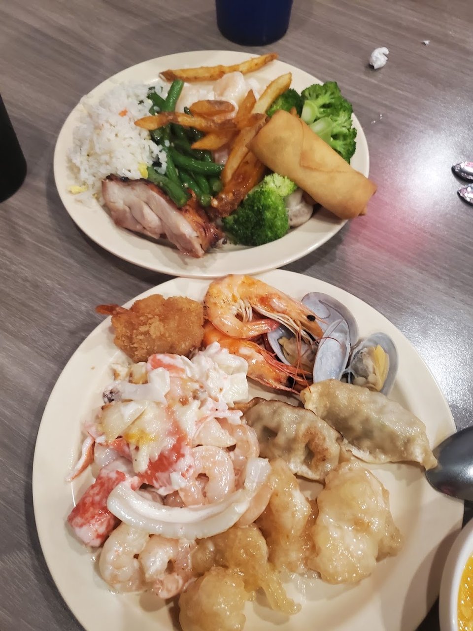 Assorted buffet plates with seafood and noodles.